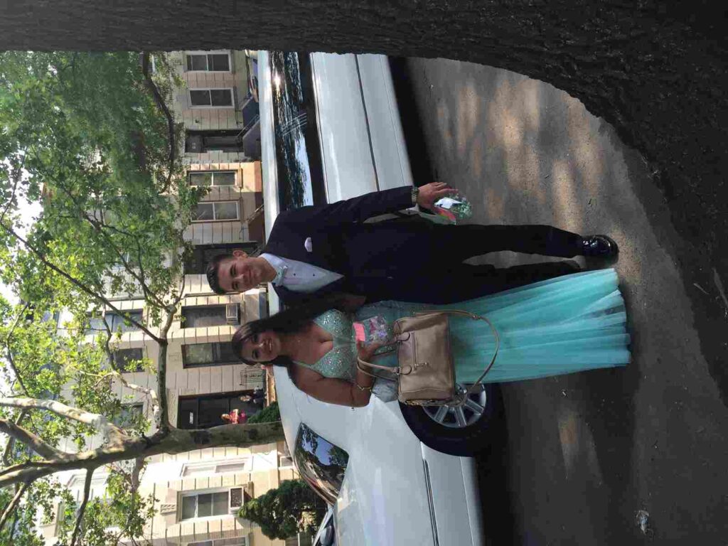couple standing in front of stretch limo